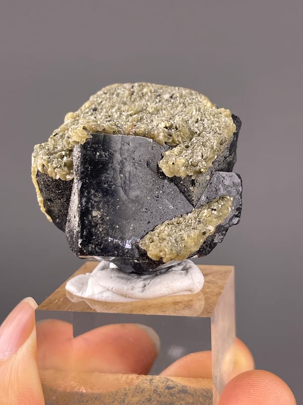 Fluorite from Fujian, China: front view of dark faces and tan coating.