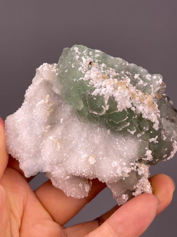Fluorite from Fujian, China: tilted crystal face with scattered white growths.