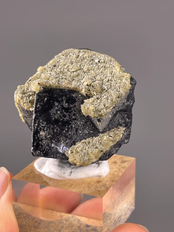 Fluorite from Fujian, China: oblique dark face bordered by pale small crystals.