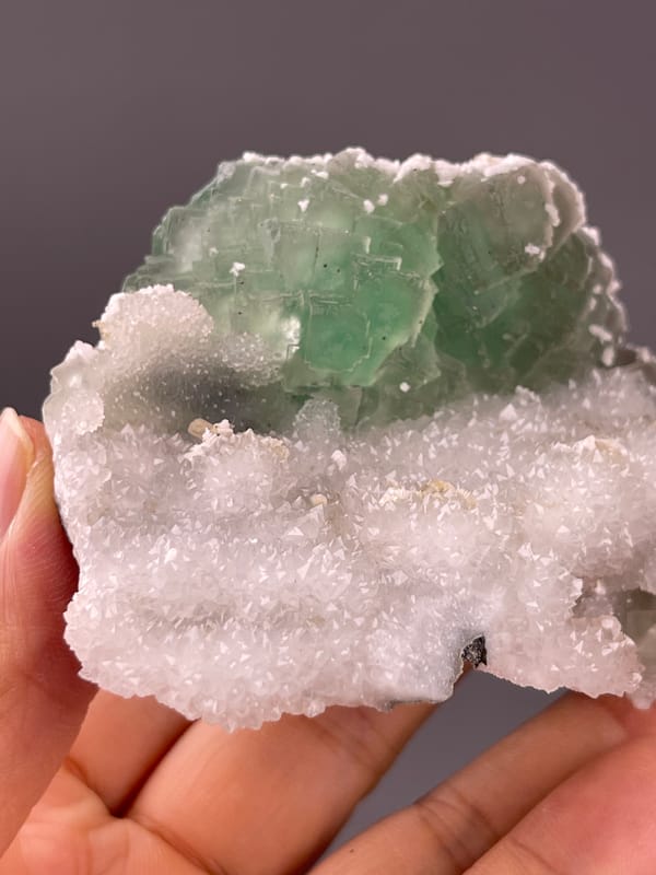 Fluorite from Fujian, China: stepped green face above fine white quartz.