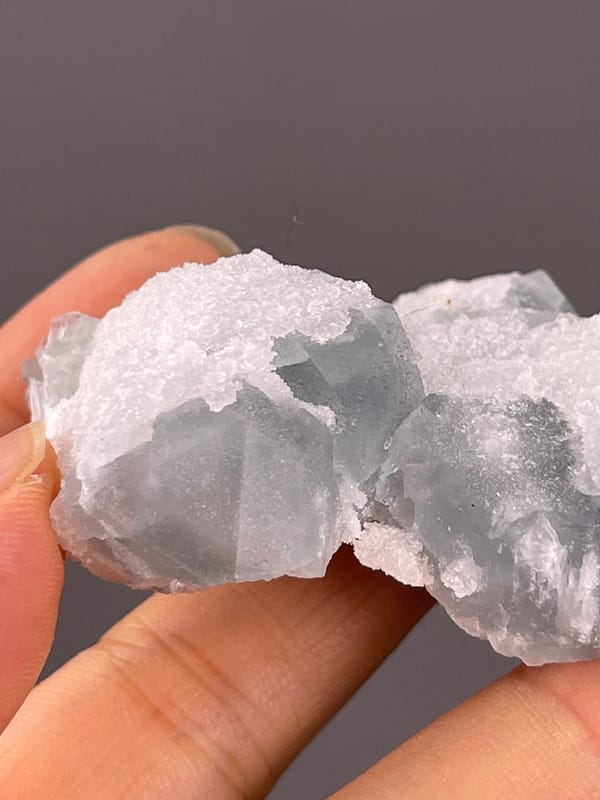 Fluorite from Fujian, China: broad blue-gray face bordered by white crystals.