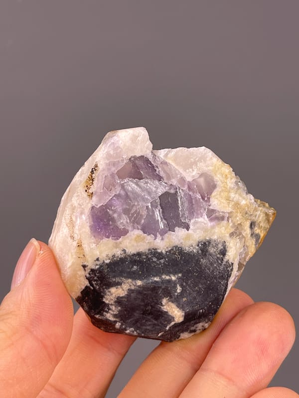 Fluorite from Fujian, China: reverse exposing a dark base beneath purple crystals.