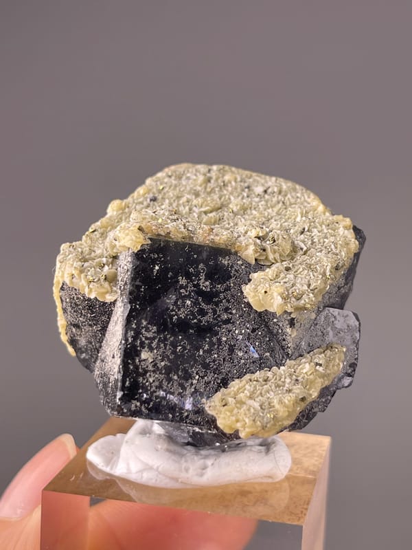 Fluorite from Fujian, China: front face with scattered pale surface marks.