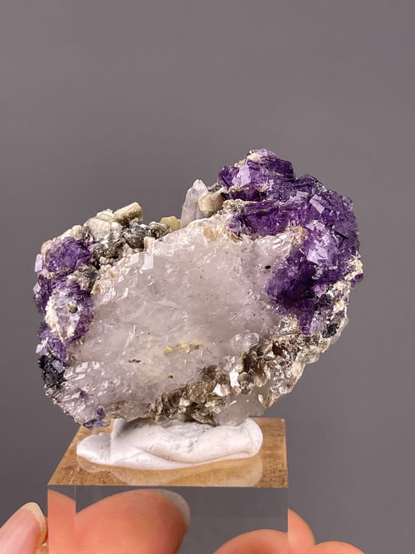 Fluorite from Yaogangxian, Hunan, China: purple fluorite bordering pale quartz and mica.