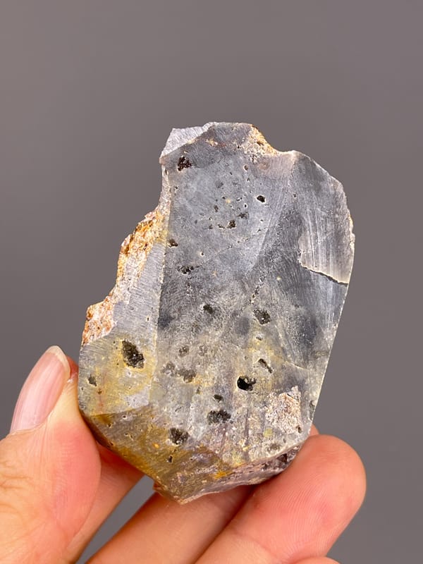 Garnet from Yunxiao, Fujian, China: flat gray reverse surface with small cavities.