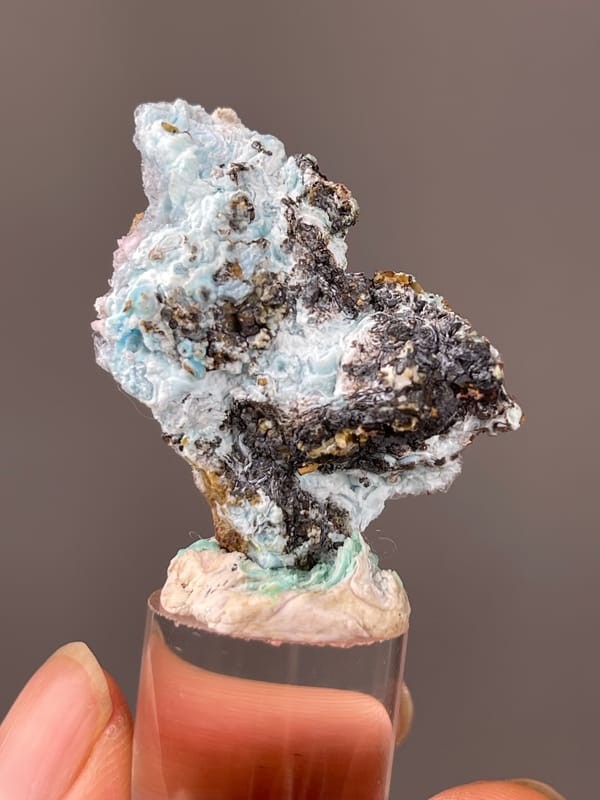 Gibbsite specimen from Qinglong, Guizhou, China, defined by pale blue botryoidal crust on brown matrix