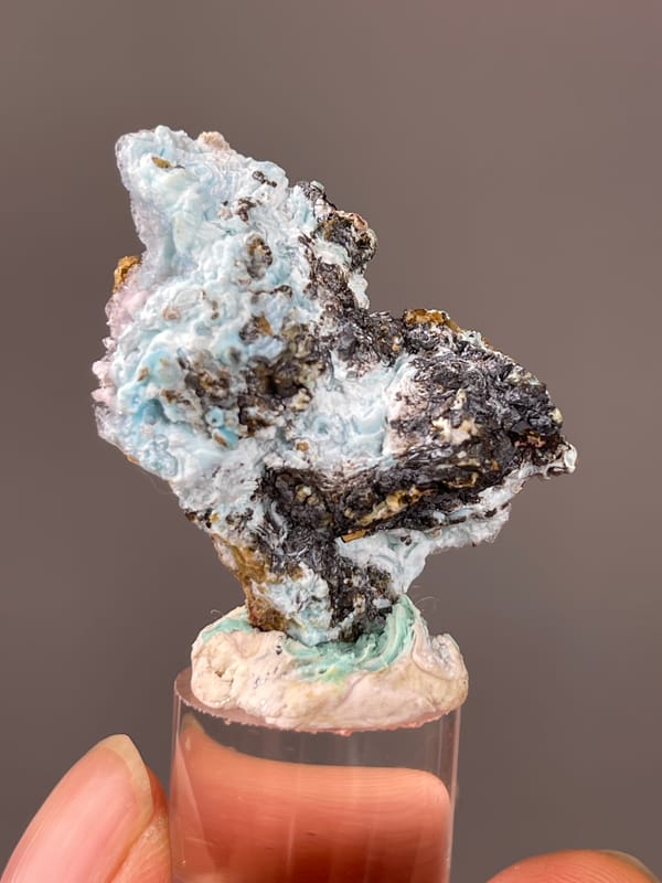 Pale blue botryoidal crust on brown matrix visible on gibbsite specimen from Qinglong, Guizhou, China