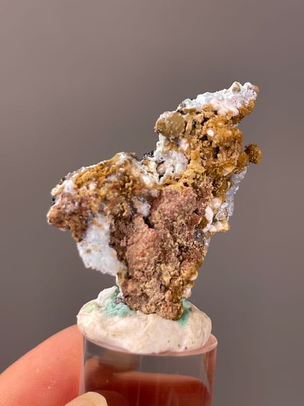 Gibbsite specimen from Qinglong, Guizhou, China, characterized by pale blue botryoidal crust on brown matrix
