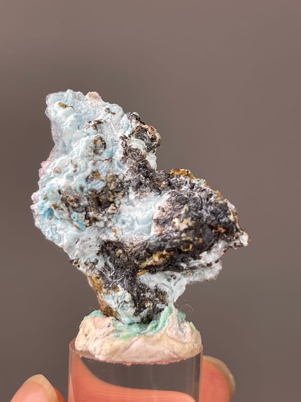 Gibbsite specimen from Qinglong, Guizhou, China showcasing pale blue botryoidal crust on brown matrix