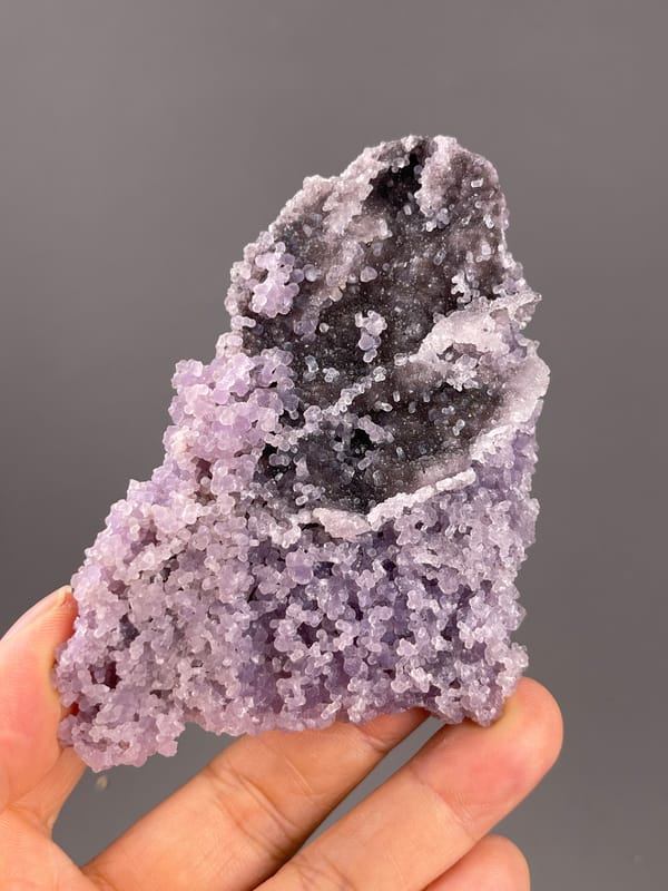 Grape Agate from Indonesia: lavender nodules around a dark cavity.