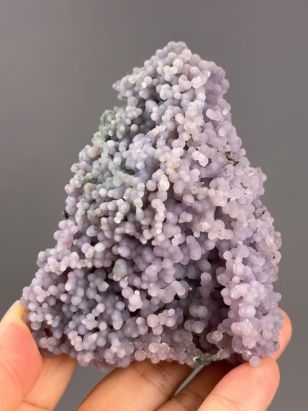 Grape Agate from Indonesia: rounded purple growths around dark recesses.