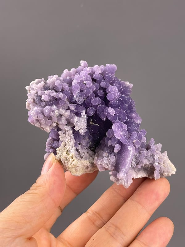 Grape Agate from Indonesia: large violet rounded growths above pale matrix.