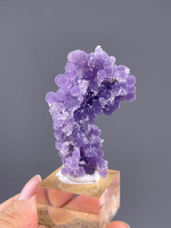 Grape Agate from Indonesia: narrow violet cluster on a display stand.