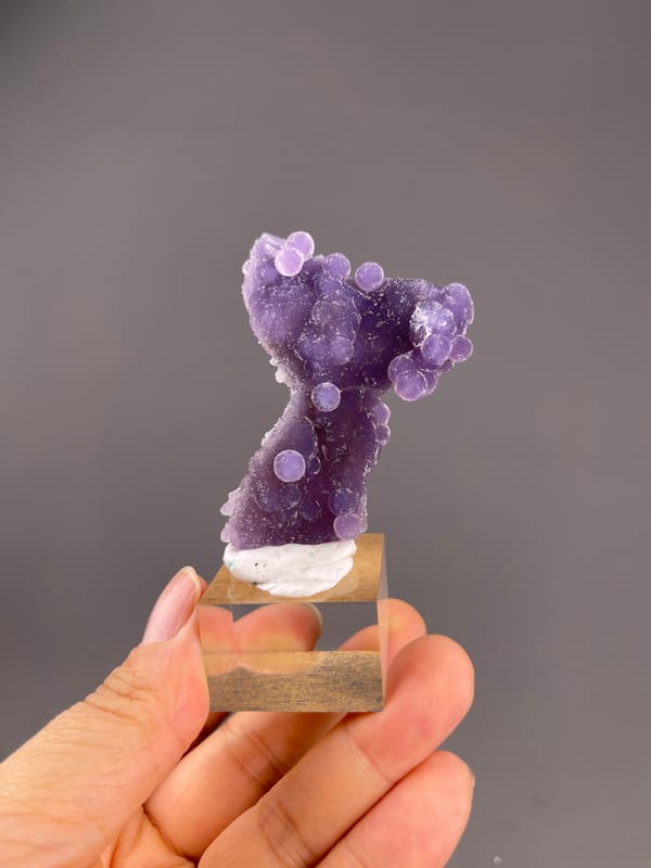 Grape Agate from Indonesia: violet rounded lobes on a display base.