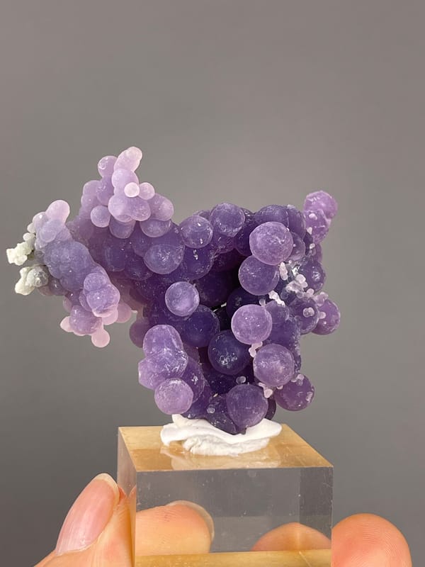 Grape Agate from Indonesia: violet rounded growths above a display base.