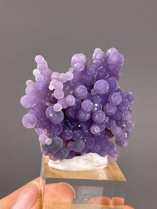 Grape Agate from Indonesia: large violet spheres among smaller pale growths.