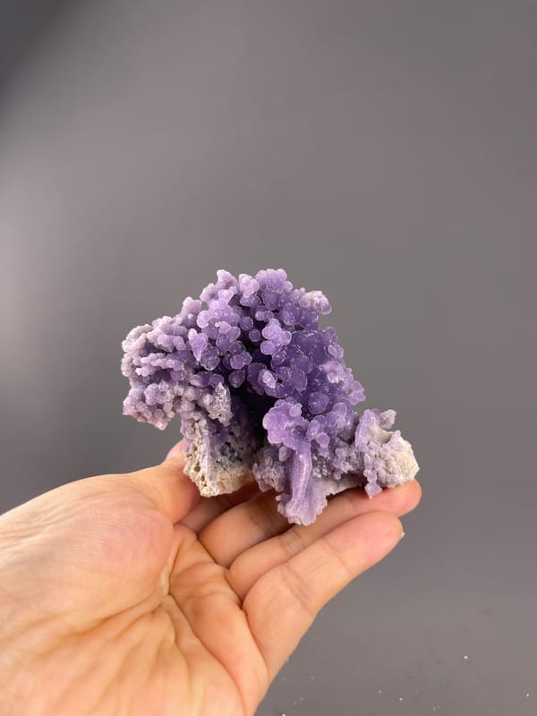 Grape Agate from Indonesia: whole irregular cluster above the palm.