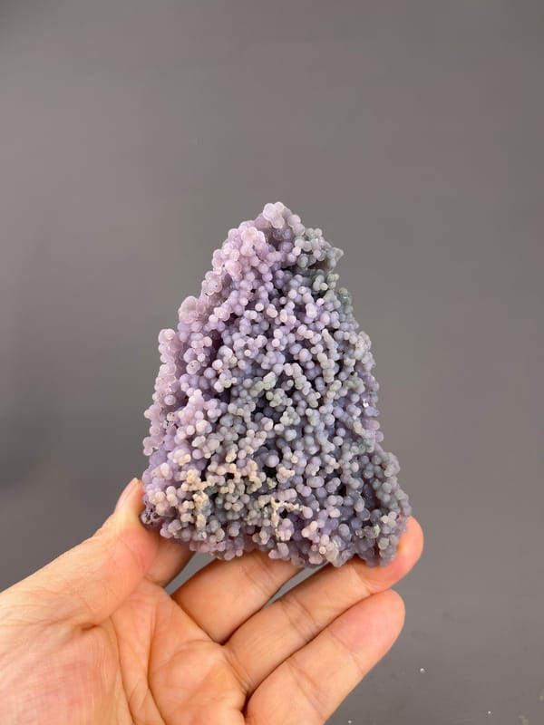 Grape Agate from Indonesia: whole pointed cluster above the palm.