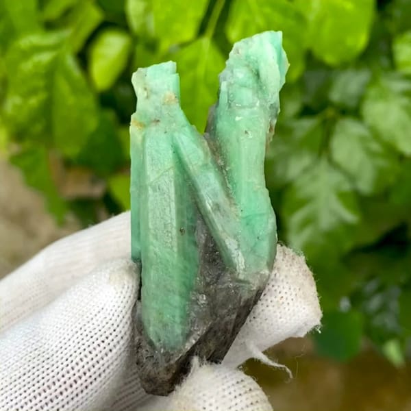 Two green emerald prisms in dark mica schist from Yunnan, China