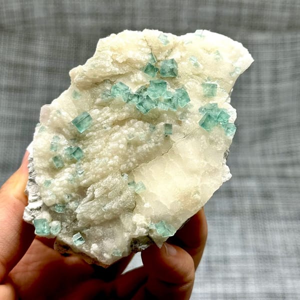 Glassy sea-green fluorite cubes on cream quartz from Madagascar