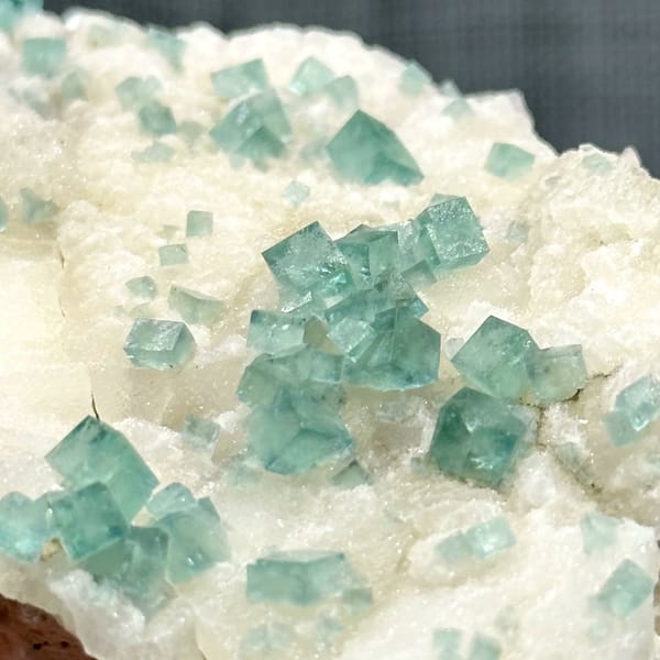 Glassy sea-green fluorite cubes on cream quartz from Madagascar, view 2 of 11
