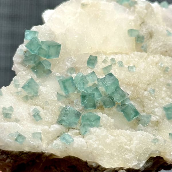 Glassy sea-green fluorite cubes on cream quartz from Madagascar, view 4 of 11