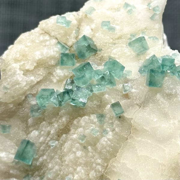 Glassy sea-green fluorite cubes on cream quartz from Madagascar, view 5 of 11