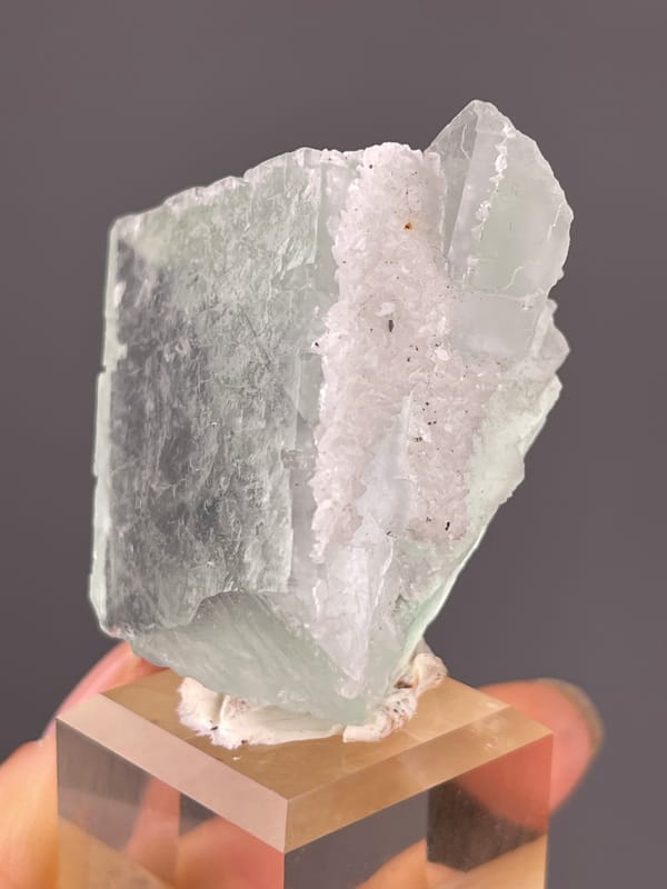 Pale green cube with frosted edge visible on green fluorite specimen from Zhejiang, China