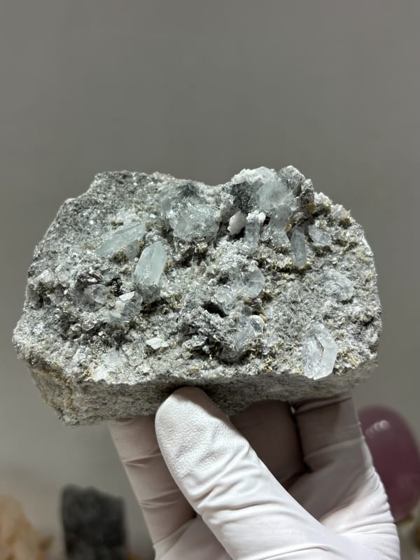 Grey matrix block dotted with pale aquamarine crystals from Xuebaoding, Sichuan, China, close-up of the crystal faces
