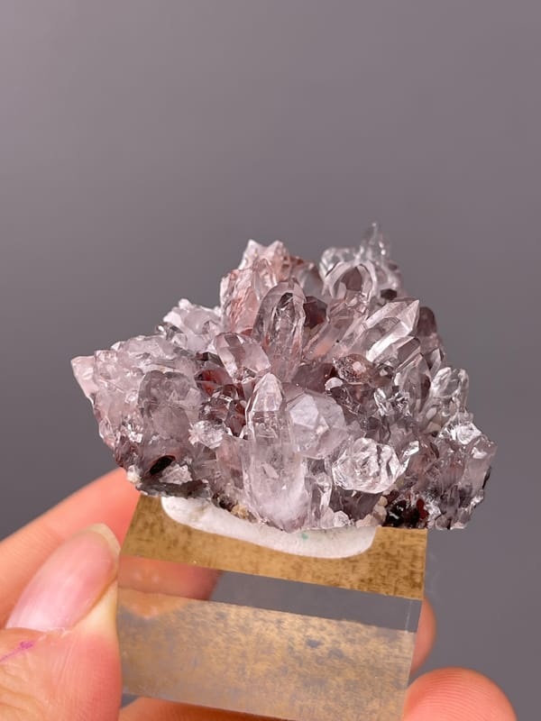 Hematite-Included Quartz specimen from Longyan, Fujian, China featuring mauve quartz prisms with red inclusions