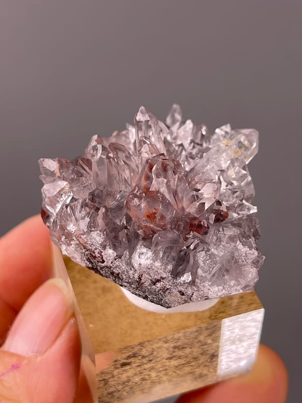 Hematite-Included Quartz specimen from Longyan, Fujian, China presenting mauve quartz prisms with red inclusions