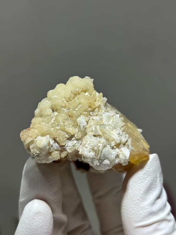 Large honey scheelite with white calcite from Xuebaoding, Sichuan, China, close-up of the crystal faces