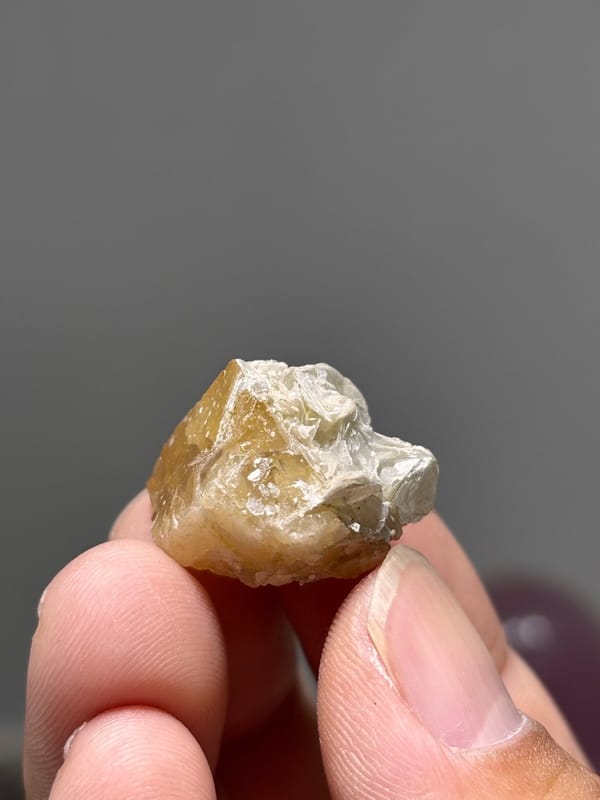Small honey scheelite crystal with mica from Xuebaoding, Sichuan, China, view 2 of 5