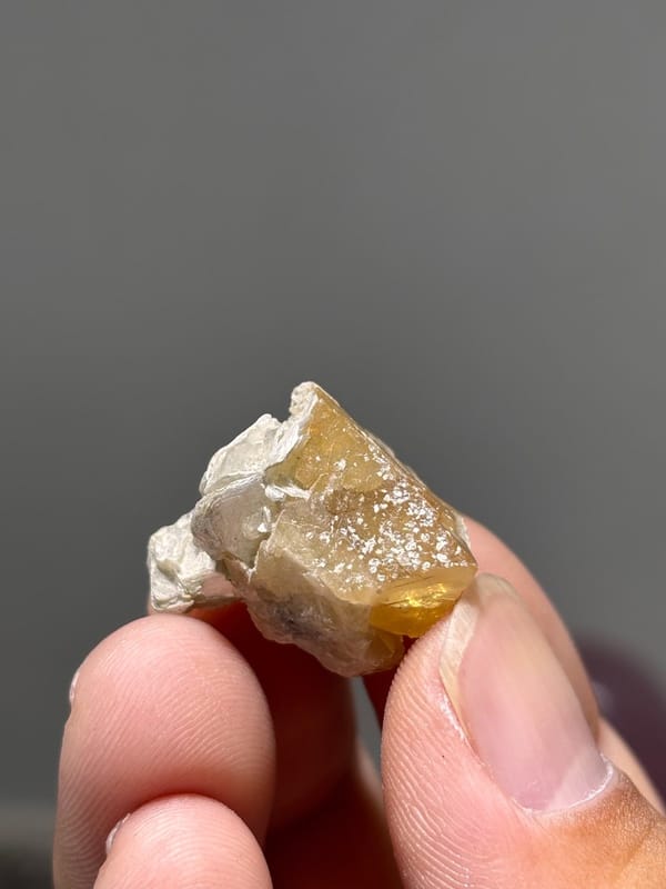 Small honey scheelite crystal with mica from Xuebaoding, Sichuan, China, view 3 of 5