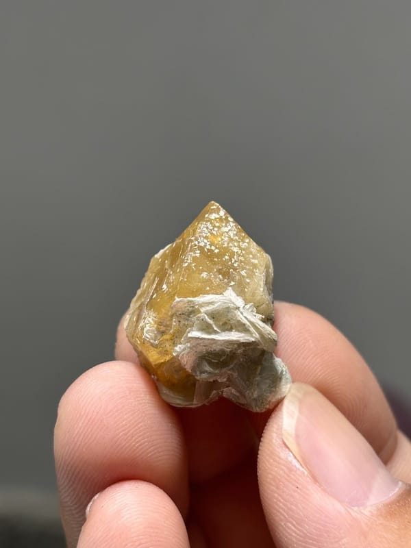 Small honey scheelite crystal with mica from Xuebaoding, Sichuan, China, view 4 of 5