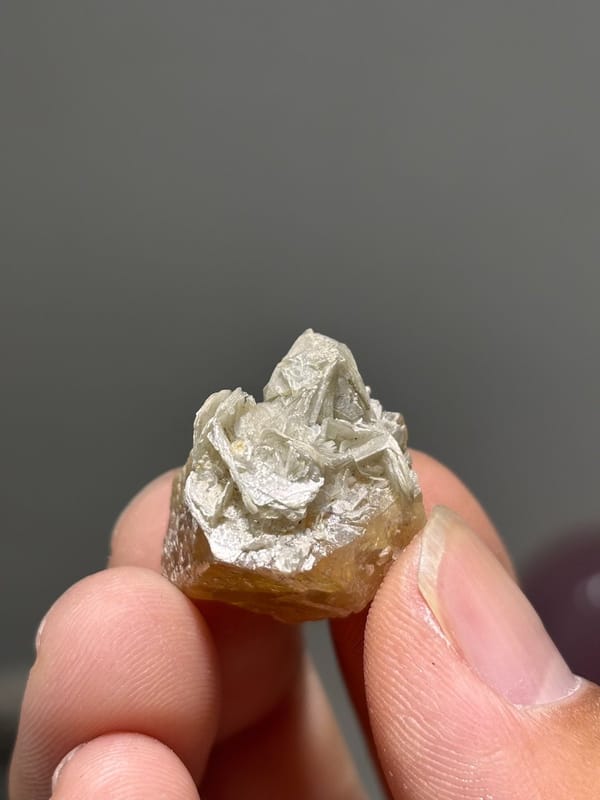 Small honey scheelite crystal with mica from Xuebaoding, Sichuan, China, view 5 of 5