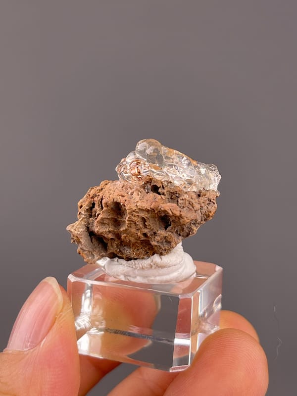 Hyalite Opal from Mexico: glassy rounded forms above rusty cavities.