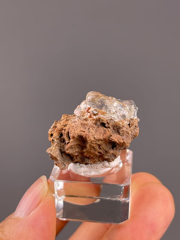 Hyalite Opal from Mexico: clear coating above deep brown surface cavities.