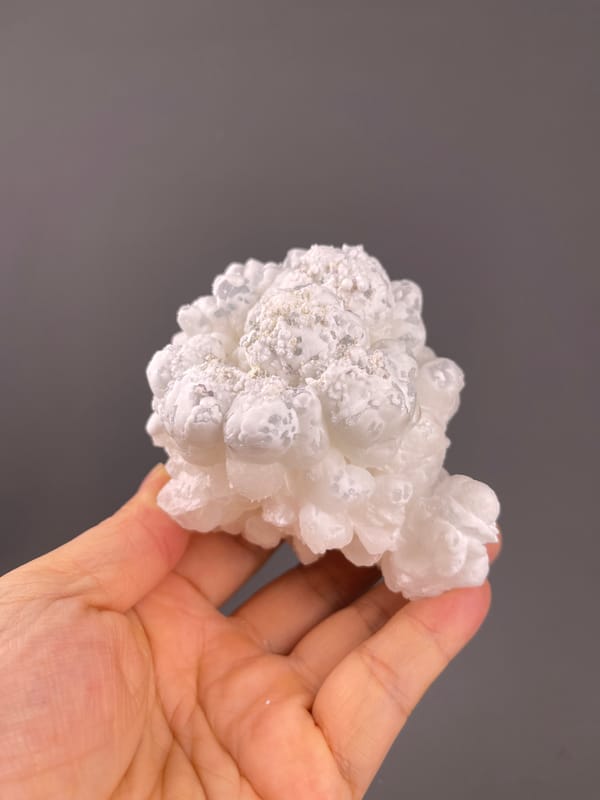 Hydrozincite from Yunnan, China: whole cloud-like cluster above fingers.