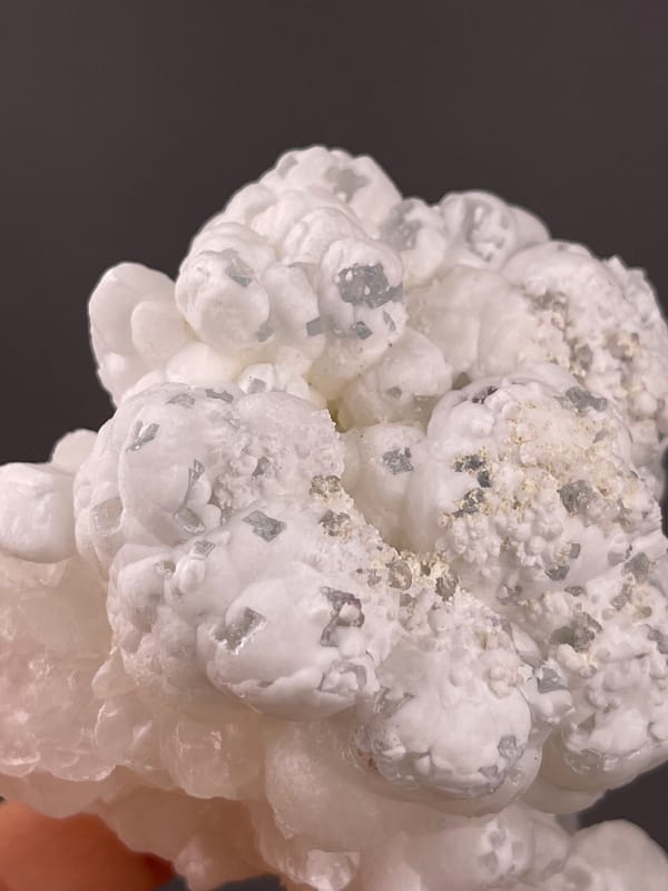 Hydrozincite from Yunnan, China: pale gray grains between white rounded forms.