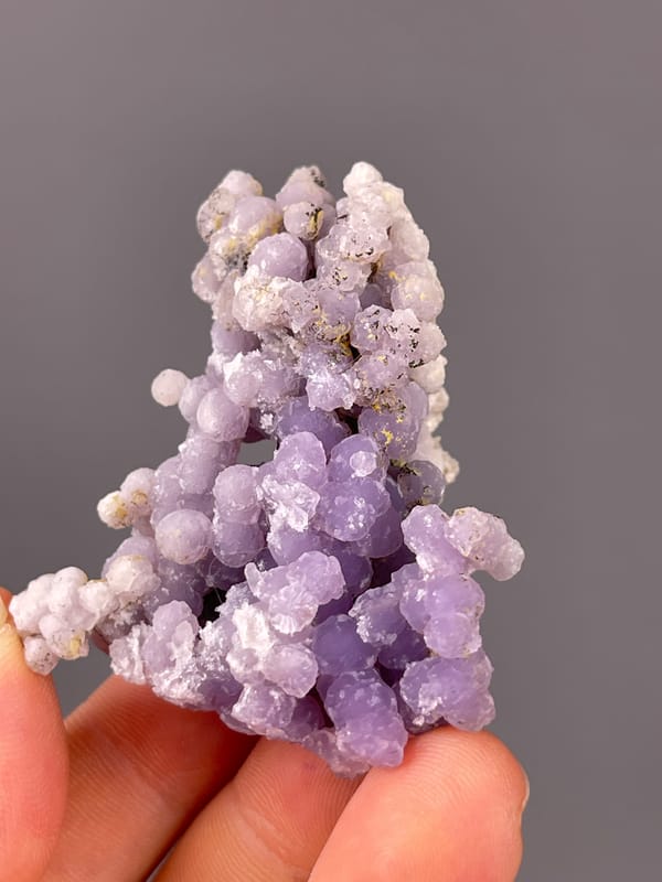 Lavender botryoidal chalcedony spheres visible on grape agate specimen from Indonesia