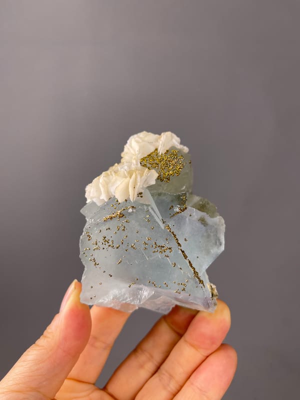 Light Blue Fluorite specimen from Yaogangxian Mine, Hunan, China showcasing pale blue cleavage faces with pyrite