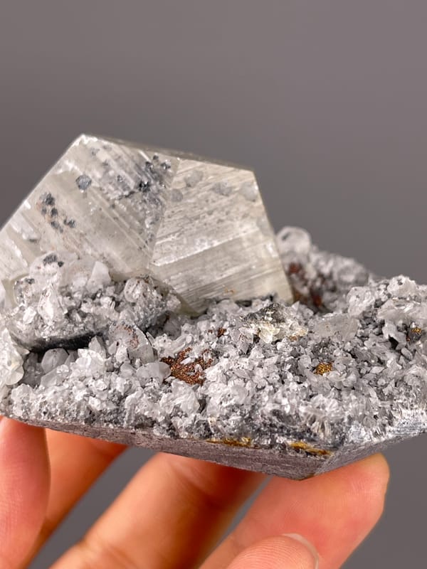 Pale beige crystal on gray druse visible on mercedes-head calcite specimen from Fujian, China