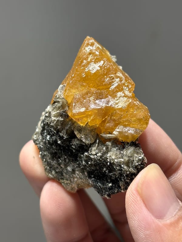 Orange scheelite floater with aquamarine and mica from Xuebaoding, Sichuan, China, close-up of the crystal faces