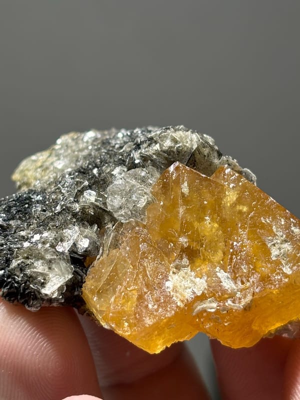 Orange scheelite floater with aquamarine and mica from Xuebaoding, Sichuan, China, reverse side
