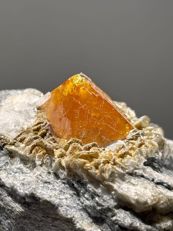 Orange scheelite on mica with fluorite at its tip from Xuebaoding, Sichuan, China, second angle