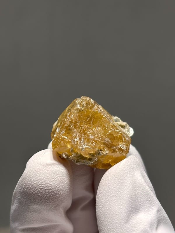 Orange scheelite crystal with mica flecks from Xuebaoding, Sichuan, China, view 2 of 6