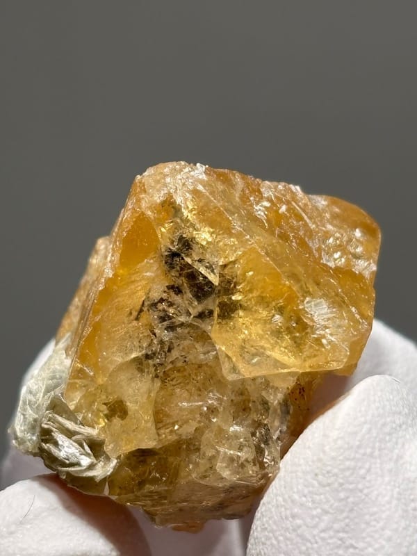 Orange scheelite crystal with mica flecks from Xuebaoding, Sichuan, China, view 5 of 6