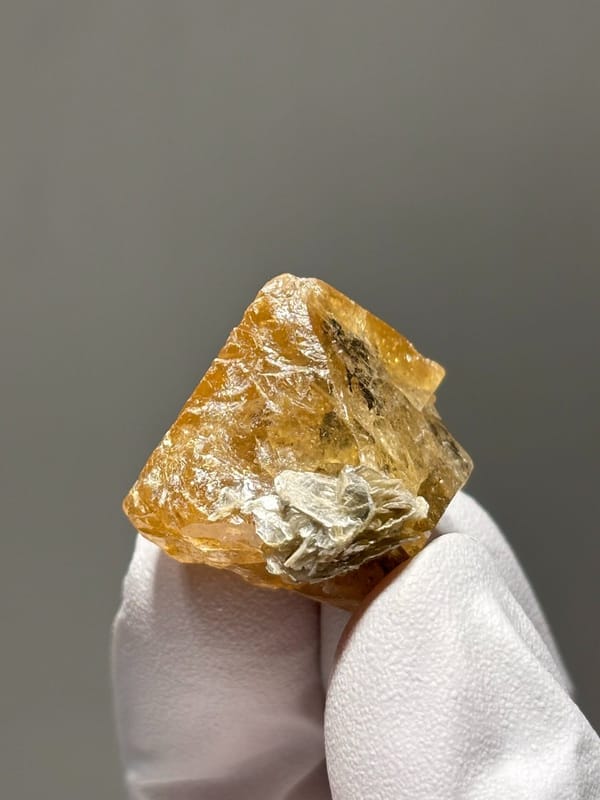 Orange scheelite crystal with mica flecks from Xuebaoding, Sichuan, China, view 6 of 6