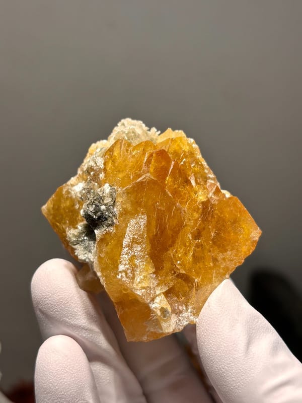 Orange scheelite cluster with mica from Xuebaoding, Sichuan, China, second angle